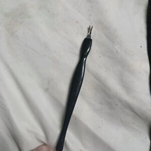 V-shaped blade cuticle trimmer with a black handle.